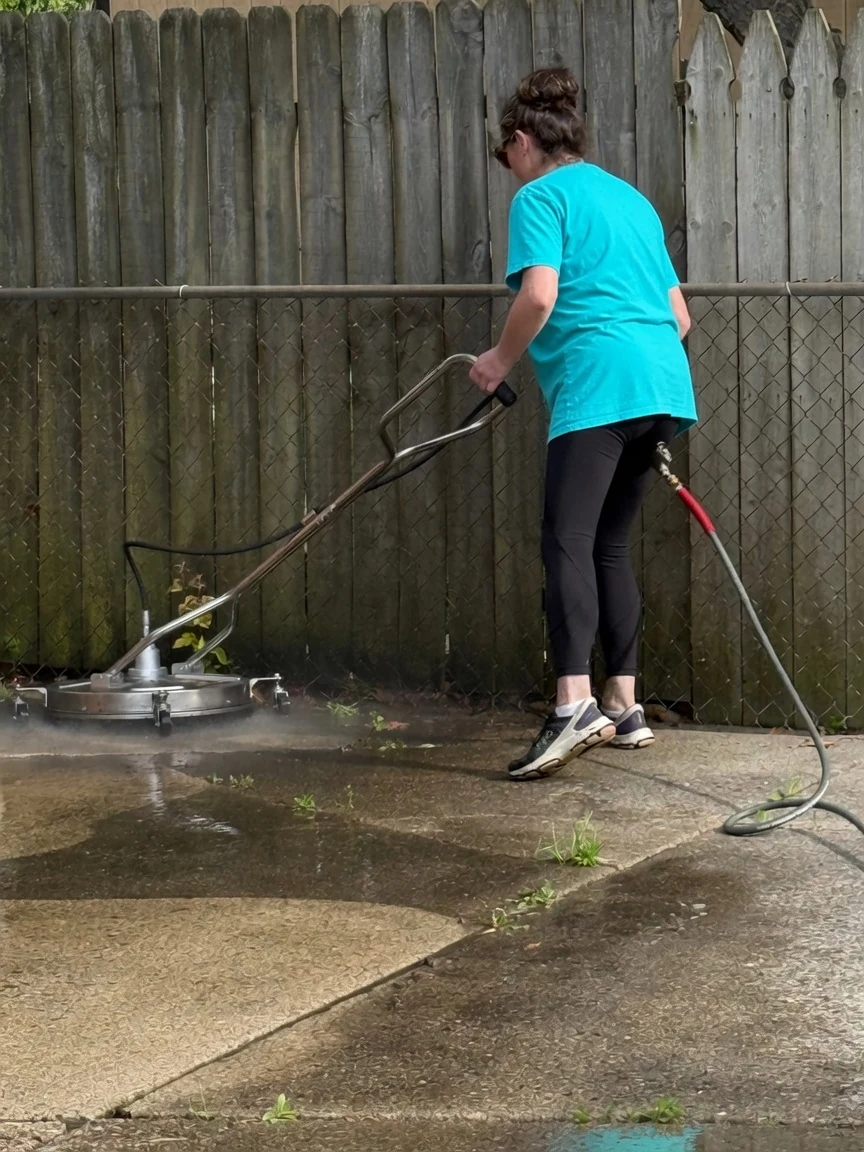 Kellie Erwin using a surface cleaner on a residential concrete area