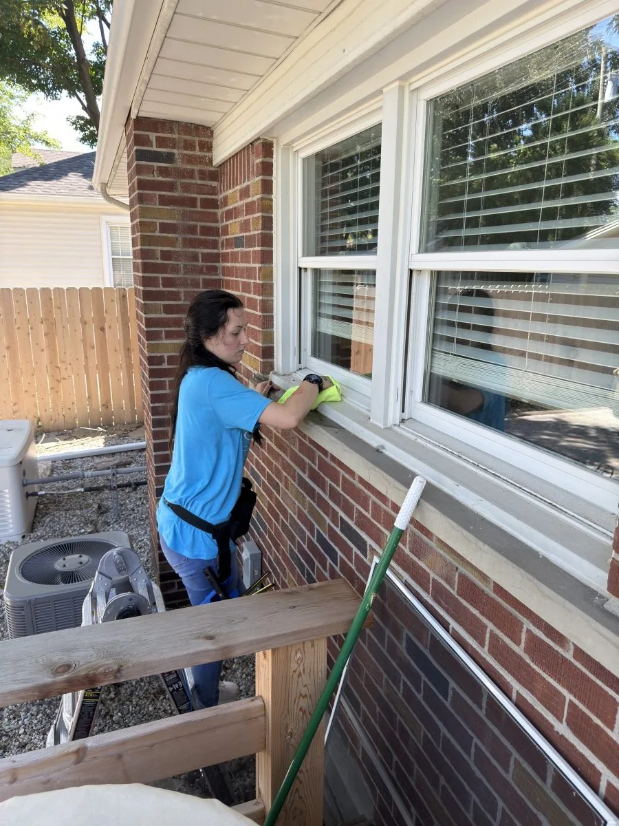 Sparkle Team cleaning technician carefully detailing a residential exterior window sill